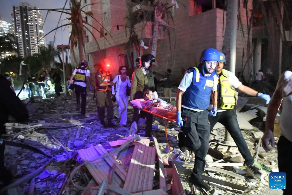 Evalue a una mujer en el lugar de ataques de misiles iranies en Petah Tikva, Israel, 16 de junio de 2025. Foto: Xinhua