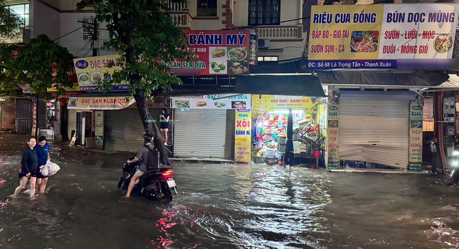 Do nuoc ngap sau nen nhieu cua hang kinh doanh tren duong Le Trong Tan phai dong cua. Cua hang nao con mo cung phai ke cao do dac de tranh uot. Anh: Vu Linh - Hoang Xuyen