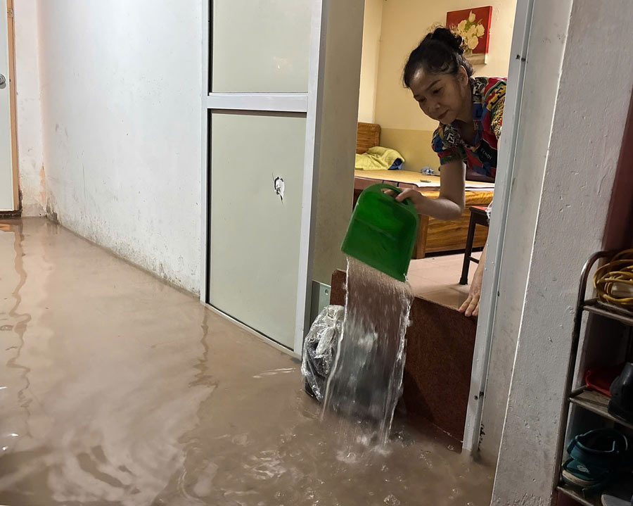 Chi Nguyen Thi Cham (khu vuc Kim Ma) cho biet, tu sang den toi nay, nuoc da tran vao nha va dang cao tren 20cm. “Lan dau tien trong doi toi thay ngap len cao nhu vay nen hoan toan bi dong, chua kip chuan bi gi. Hien gia dinh chi con cach tat nuoc ra ngoai de khac phuc tam thoi” - chi Cham chia se. Anh: Huyen Trang