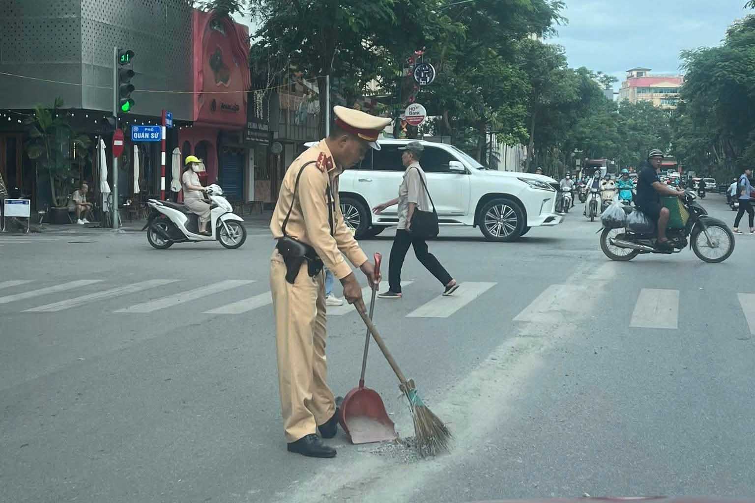 Mot can bo Canh sat giao thong thu don trac thai, vat lieu xay dung tai nut giao pho Ly Thuong Kiet - Quan Su, sang 18.6. Anh: Nguoi dan cung cap