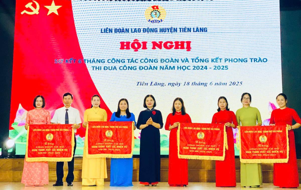 El representante de la Federacion Laboral de Hai Phong otorgo la bandera de emulacion a los colectivos. Foto: Huong Mai