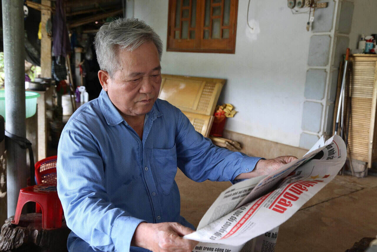 Ong Bui Van Cuu, nguoi co uy tin xom Cai (xa Vu Binh), tim hieu thong tin phap luat qua bao chi de tuyen truyen toi ba con. Anh: Binh Khang