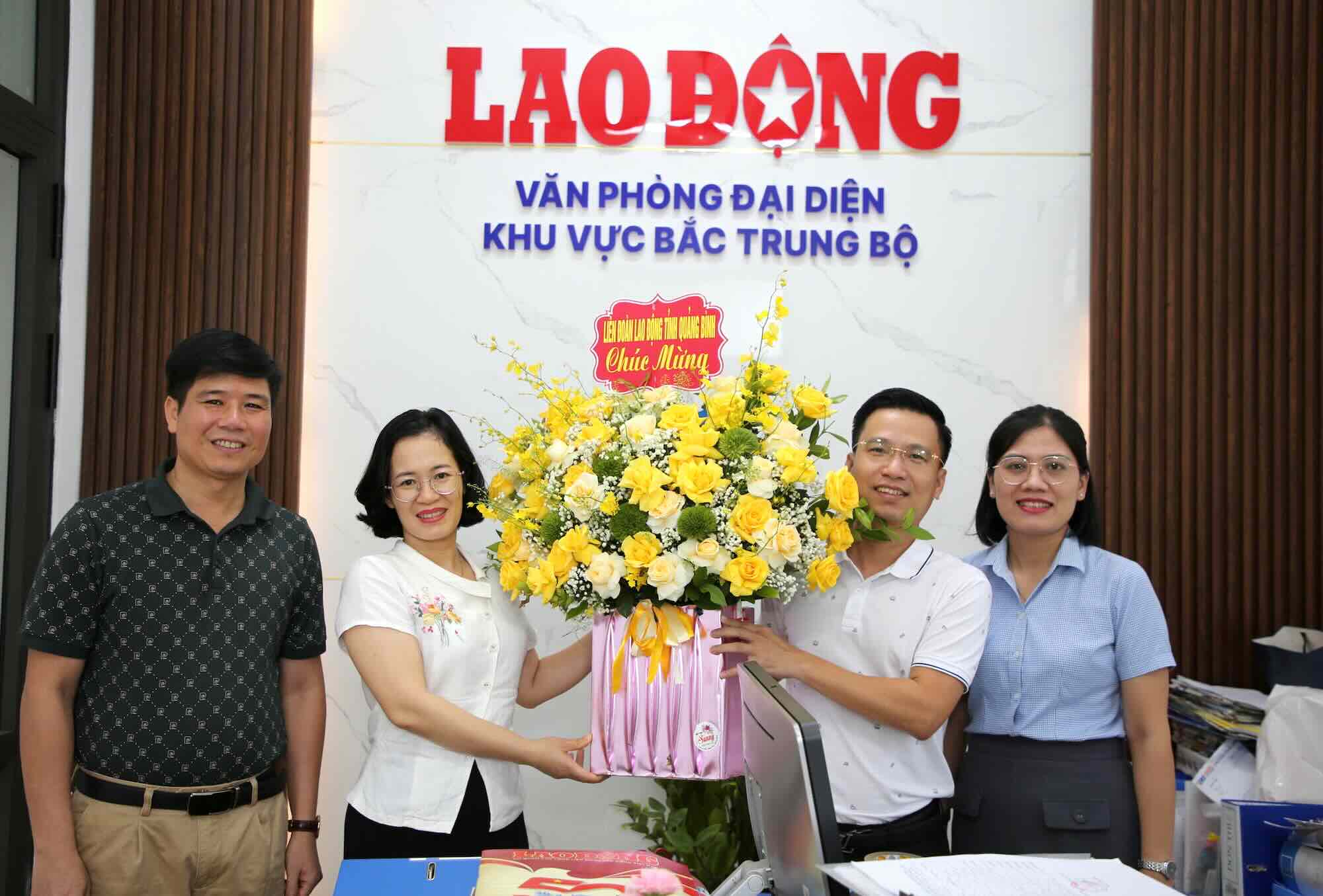 El periodista Le Phi Long - Jefe de la Oficina Representante del North Central Labor Parnerpaper (segundo, fuera de la derecha) recibio flores de felicitacion de la Federacion Laboral de la provincia de Quang Binh. Foto: Cong Sang