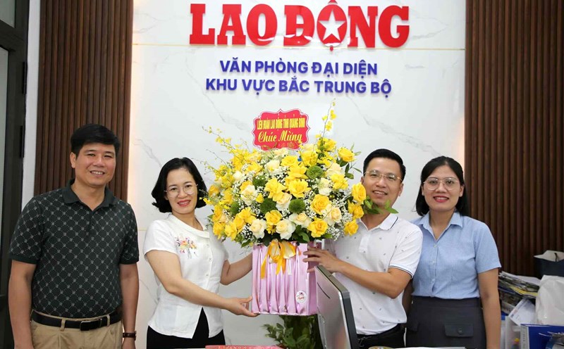 Journalist Le Phi Long - Head of the Lao Dong Newspaper Representative Office in the North Central region (2nd, outside, right) received congratulatory flowers from the Quang Binh Provincial Federation of Labor. Photo: Cong Sang