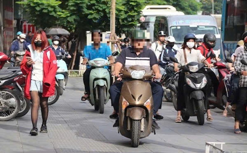 Motorbikes climb the sidewalk to move on Ho Tung Mau Street (Cau Giay District, Hanoi City). Photo: My Linh