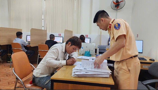 Los oficiales de policia de trafico guian a los candidatos a completar el procedimiento antes de ingresar a la seccion de prueba teorica en la computadora. Foto: Departamento de Policia de Trafico de Hoa Binh