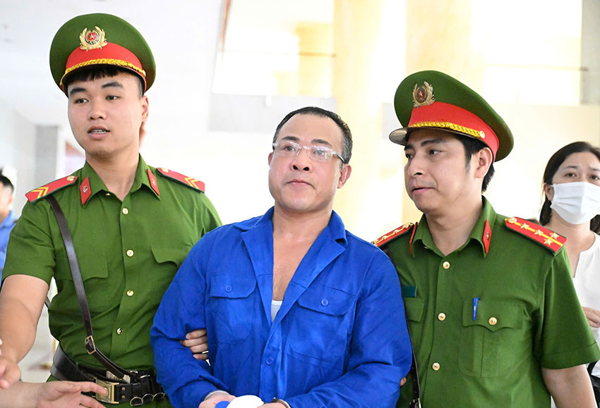 Nghiêm Quang Minh - chủ chung cư mini bị cháy, khi bị dẫn giải vào phòng xử án chiều 19.6. Ảnh: Quang Việt