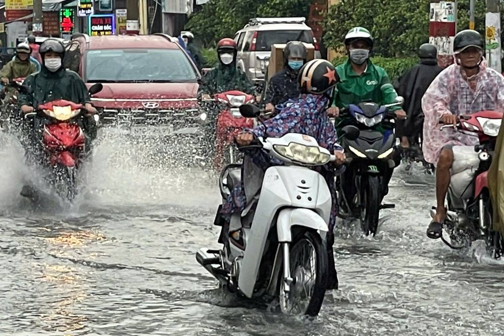 Nguoi dan dat xe may qua doan ngap sau tren duong Le Van Viet, chieu 19.6