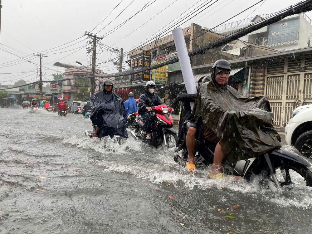 Cac phuong tien giao thong di chuyen cham qua doan ngap hon nua banh xe tren duong To Ngoc Van. Ảnh: Minh Tam