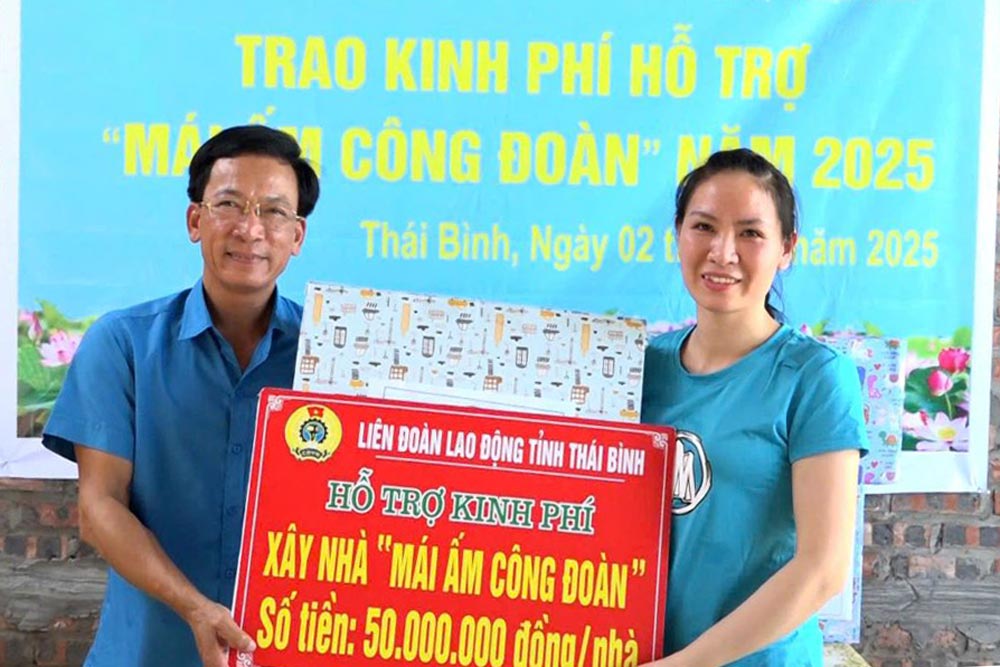 Vice President of Thai Binh Provincial Federation of Labor Nguyen Thanh Binh presented funding to support house building from the Trade Union Shelter Fund to union member Nguyen Thi Nhinh. Photo: Ba Manh