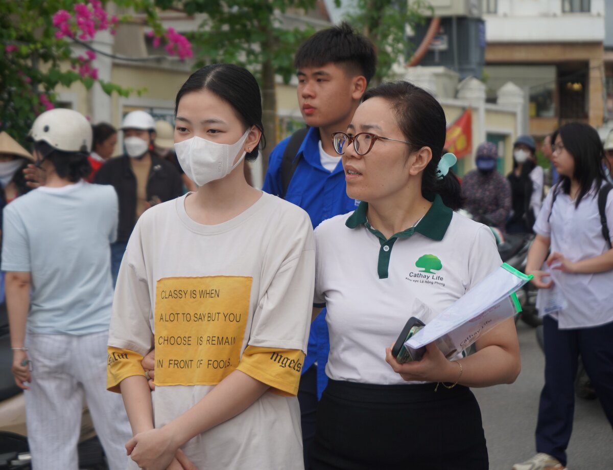 Nhieu phu huynh co mat tai diem thi, dong vien con em minh binh tinh buoc vao ki thi quan trong. Ảnh: Mai Dung