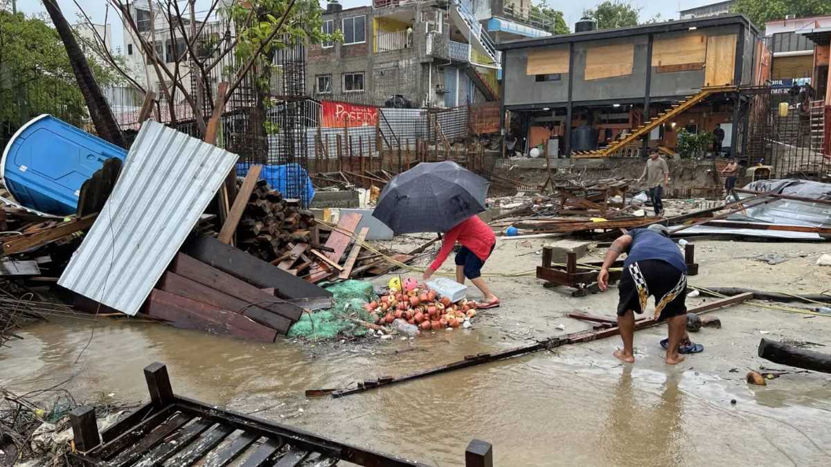 Nguoi dan dia phuong don dep dong do nat sau khi con bao Erick di qua Bahia Principal, Puerto Escondido, tieu bang Oaxaca, Mexico, ngay 19.6.2025. Anh: AFP