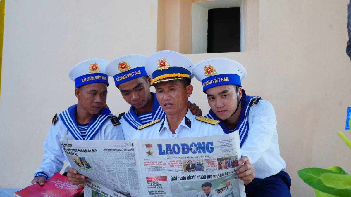 Officers and soldiers on An Bang Island read Lao Dong newspaper. Photo: Mai Huong