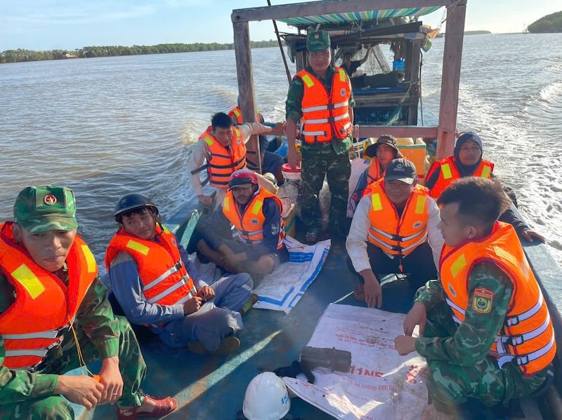 Can bo chien si Don Bien phong Vinh Hai cung tau ca ngu dan Dinh Van Hao dua 7 cong nhan vao bo.