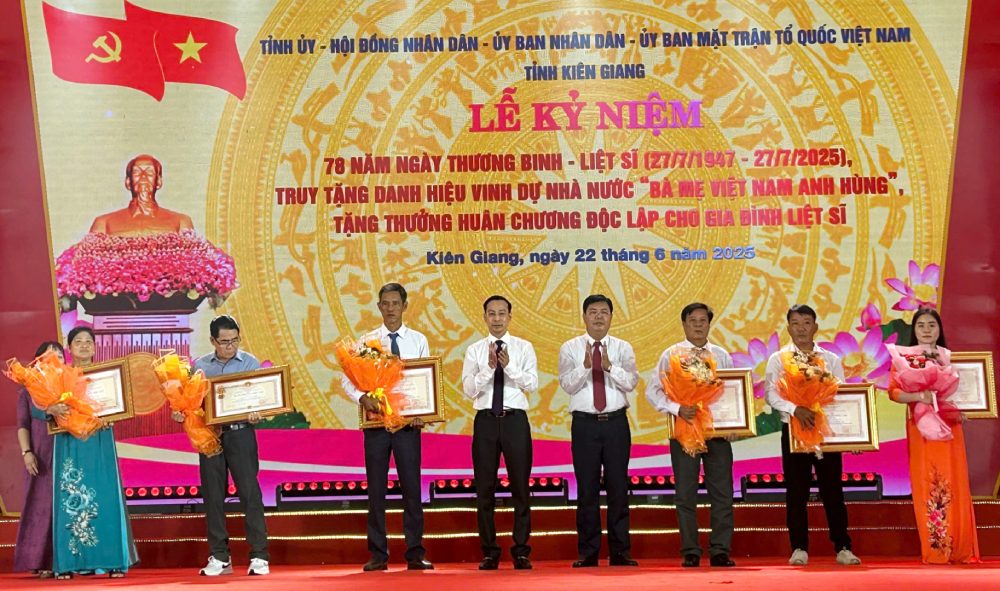 Bi thu Tinh uy Kien Giang Nguyen Tien Hai va Chu tich UBND tinh Kien Giang Nguyen Thanh Nhan trao Huan chuong doc lap hang Ba cho dai dien than nhan cac gia dinh. Anh: Ngoc Mai