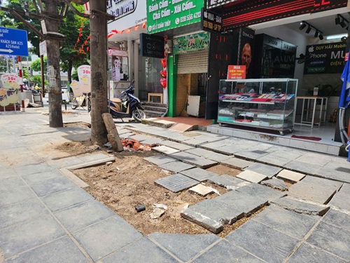 Vỉa hè đường Xuân Thuỷ, Cầu Giấy đào lên thi công không hoàn trả trở nên nham nhở gây khó khăn cho người đi bộ. Ảnh: Minh Hạnh
