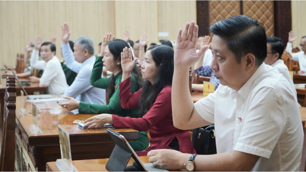 Votando a traves de la resolucion para ajustar y complementar el plan de inversion publica a mediano plazo para el presupuesto local para el periodo 2021-2025 en la provincia de Kien Giang. Foto: Nguyen Anh