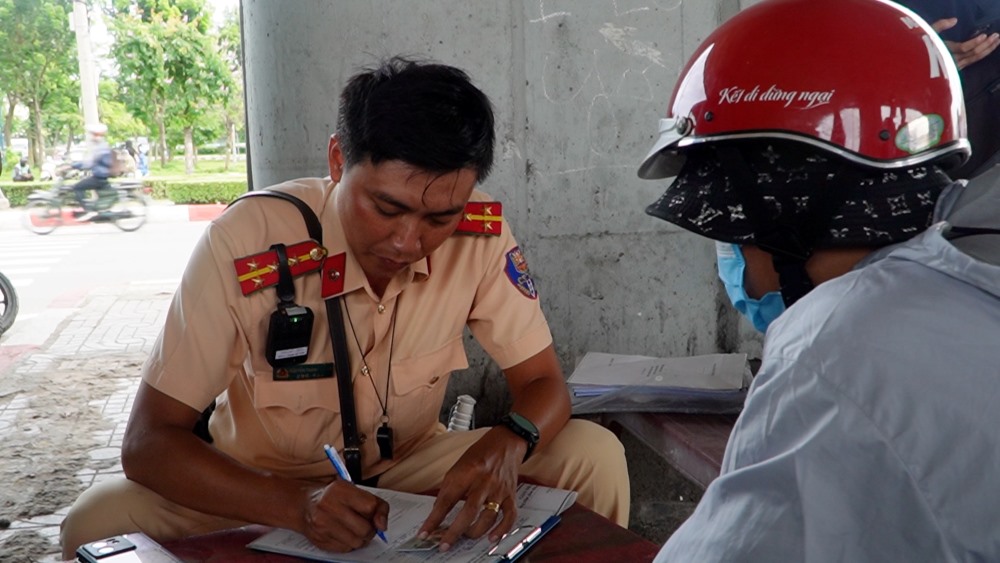 CSGT tien hanh lap bien ban anh M, xu phat 5 trieu dong va tam giu phuong tien. Anh: Ly Linh