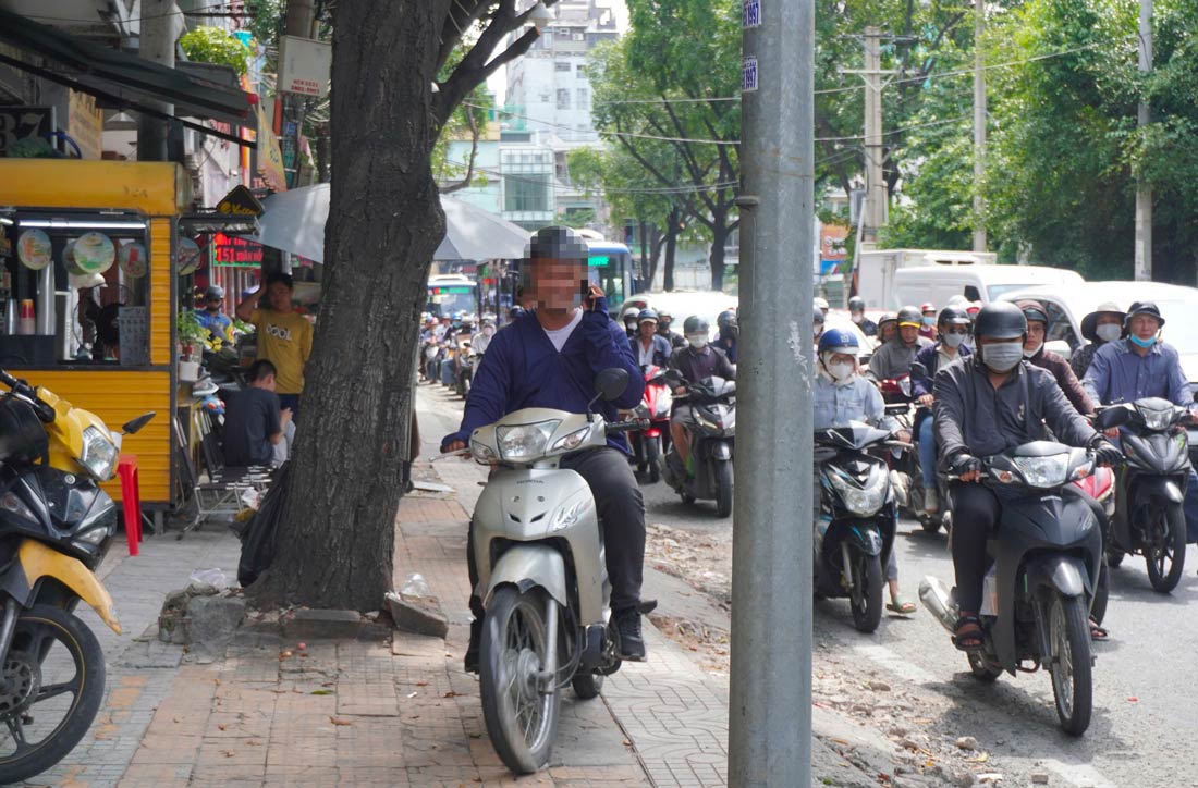 Nguoi dieu khien xe may vua di tren via he, vua nghe dien thoai di dong. Ghi nhan tai duong Xuan Hong, quan Tan Binh. Anh: Quynh Nhu