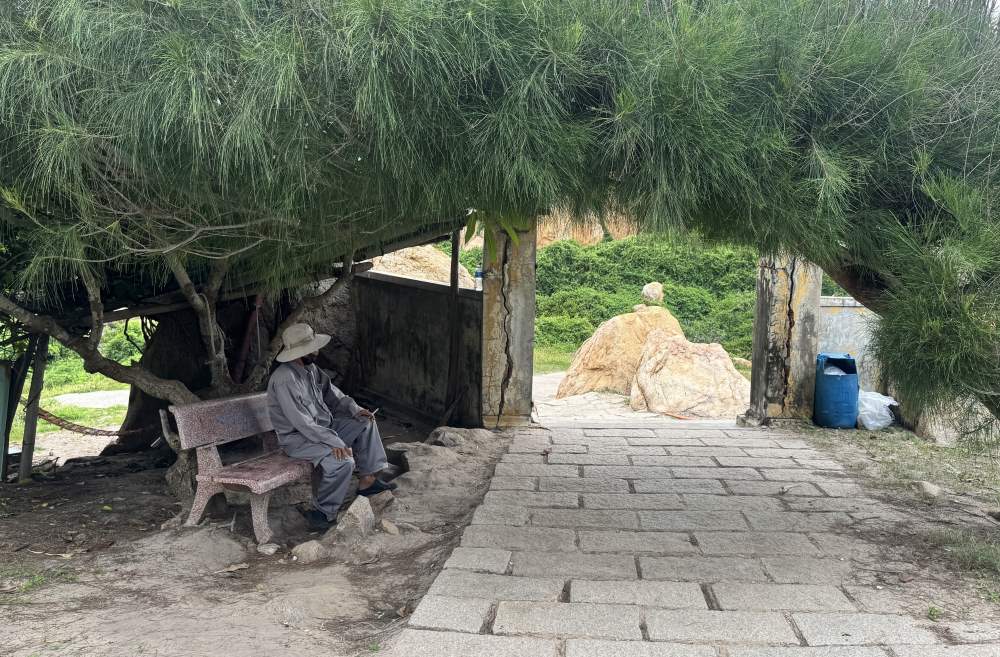 Some people stand guard at the entrance to Ke Ga lighthouse to collect fees from tourists. Photo: Duy Tuan