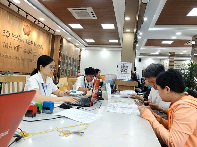 Funcionarios y funcionarios del Comite Popular del Distrito 11 (Ciudad de Ho Chi Minh) Asentamiento de documentos para personas. Foto: Minh Quan