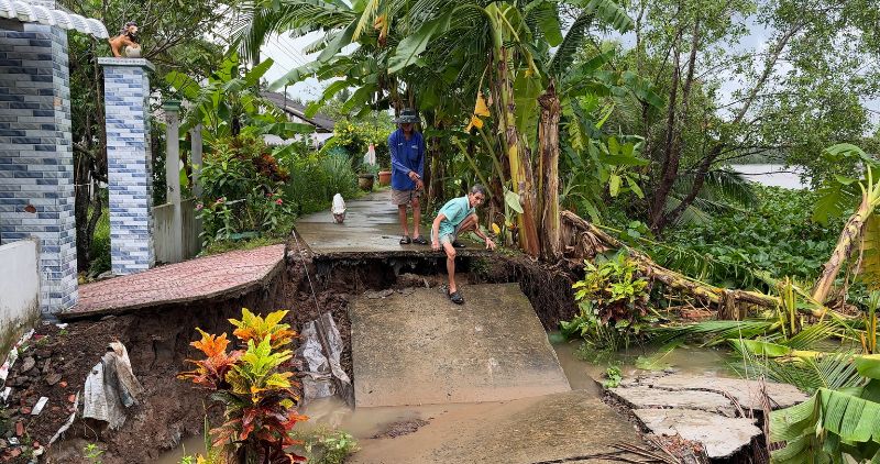 Two people watched the landslide right in front of their house, where the road surface had completely broken. Photo: Hoang Loc