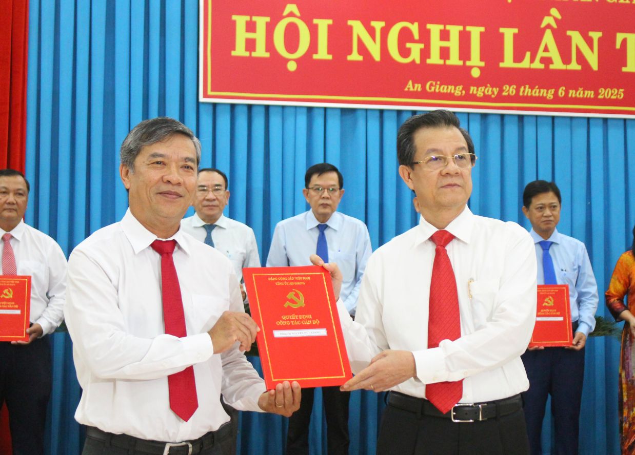 Bí thư Tỉnh ủy An Giang Lê Hồng Quang (phải ảnh) trao Quyết định cho ông Nguyễn Hữu Giang  nghỉ hưu trước tuổi theo nguyện vọng. Ảnh: Lục Tùng