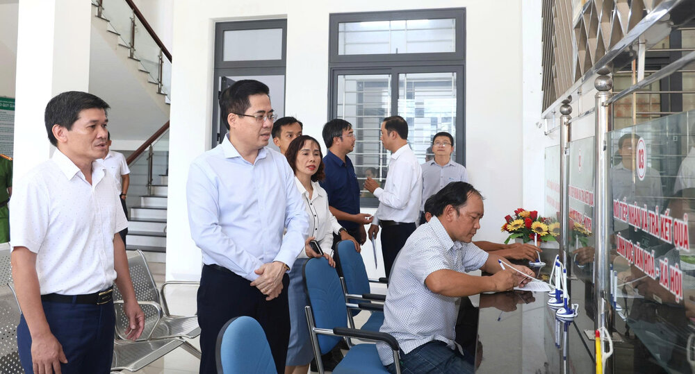 Ong Nguyen Hoang Giang - Chu tich UBND tinh Quang Ngai (thu 2 tu trai qua) trao doi voi dai dien lanh dao huyen Tu Nghia ve bo tri Trung tam Phuc vu hanh chinh cong xa moi. Anh: Vien Nguyen