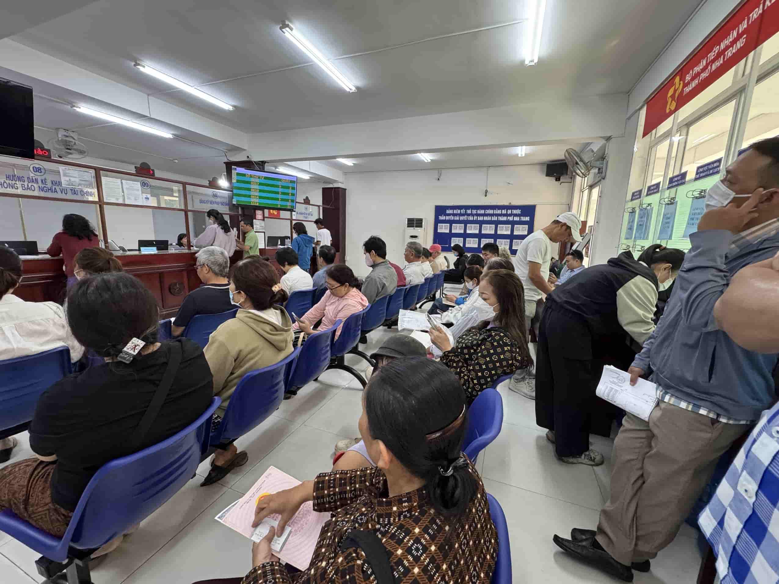 La gente de Khanh Hoa esta esperando para resolver procedimientos administrativos en una parte de una puerta. Foto: Huu Long