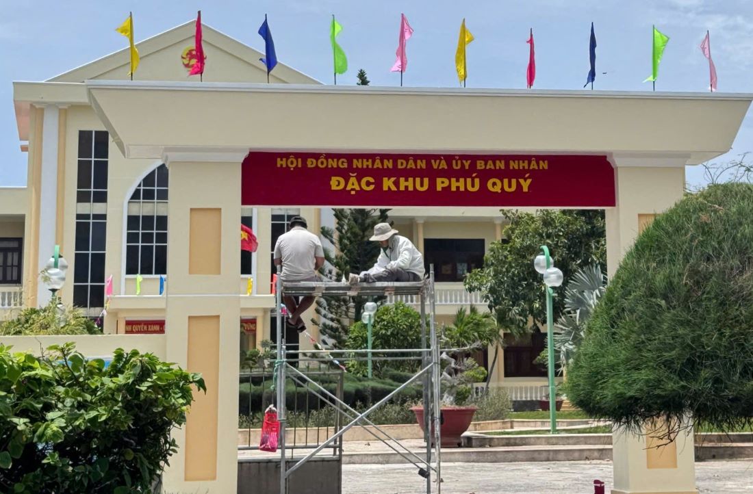 Thi cong thay doi bang tren truoc tru so HDND - UBND huyen dao Phu Quy. Anh: Duy Tuan