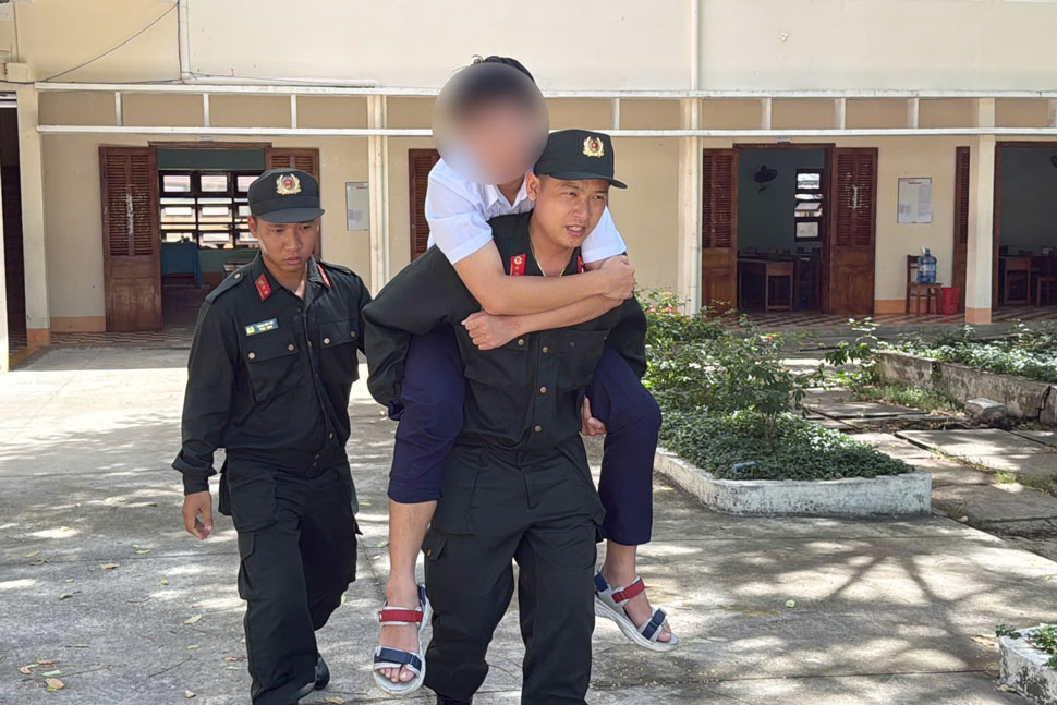 D.V.P (SN 2007, un estudiante de Quoc Hoc Quy Nhon, Quy Nhon City, Binh Dinh) fue llevado por un soldado de la policia movil a la sala de examen. Foto: Sy Luan
