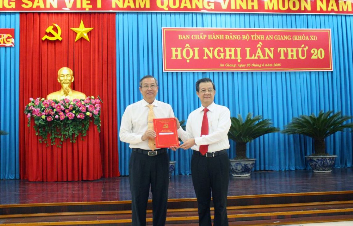 Bi thu Tinh uy An Giang Le Hong Quang (phai) trao Quyet dinh cua Ban Bi thu Trung uong Dang cho ong Le Van Nung nghi huu truoc tuoi theo nguyen vong. Anh: Luc Tung