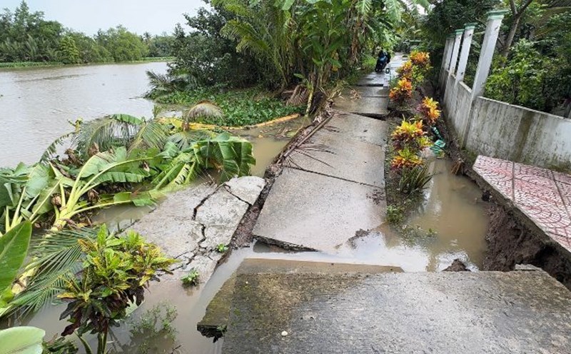 The road surface is cracked and sliding down to Cai Ngang River. The dykes continue to retreat, threatening many households along the river. Photo: Hoang Loc