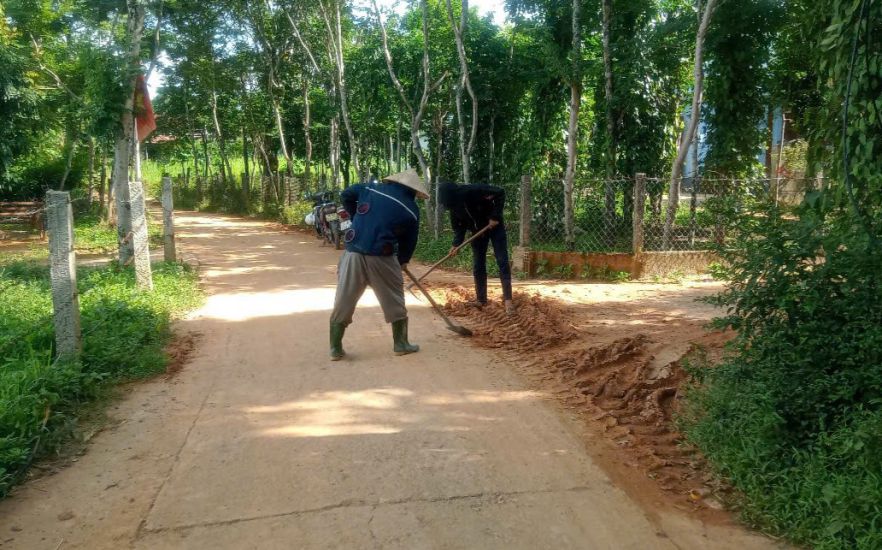 The construction unit collects mud on the residential road that was covered with rocks and soil after heavy rain. Photo: Han Nguyen