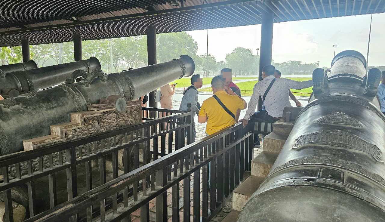 Du khach ngoi len hang rao cua Cuu vi than cong. Anh: Nguyen Luan