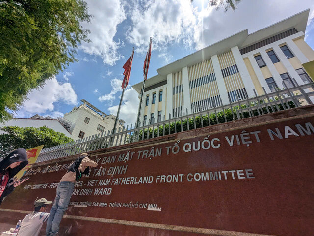Hien cong nhan dang lap dat bang ten tru so lam viec moi cua phuong Tan Dinh. Anh: Anh Tu
