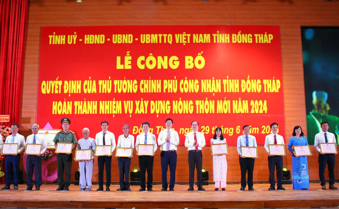 Chu tich UBND tinh Dong Thap Tran Tri Quang va Pho Chu tich UBND tinh Dong Thap Huynh Minh Tuan trao Bang khen UBND tinh Dong Thap cho tap the, ca nhan co thanh tich xuat sac trong xay dung nong thon moi. Anh: Lam Dien 