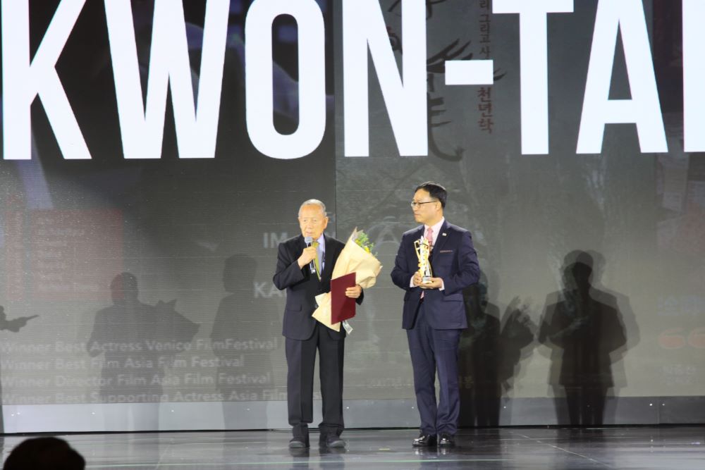 Ong Kim Dong Ho – Nha sang lap va Nguyen Chu tich Lien hoan phim Quoc te Busan – cung ong Choi Youngsam - Dai su dac menh toan quyen Han Quoc tai Viet Nam thay mat dao dien Im Kwon Teak nhan voi Giai Thanh tuu Dien anh. Anh: Tran Thi