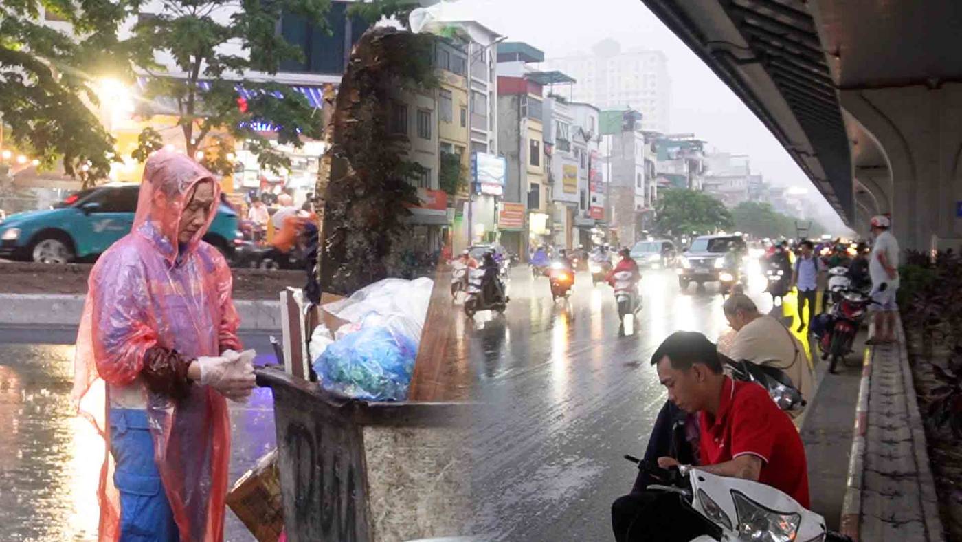 Los trabajadores trabajan duro para trabajar bajo fuertes lluvias en Hanoi