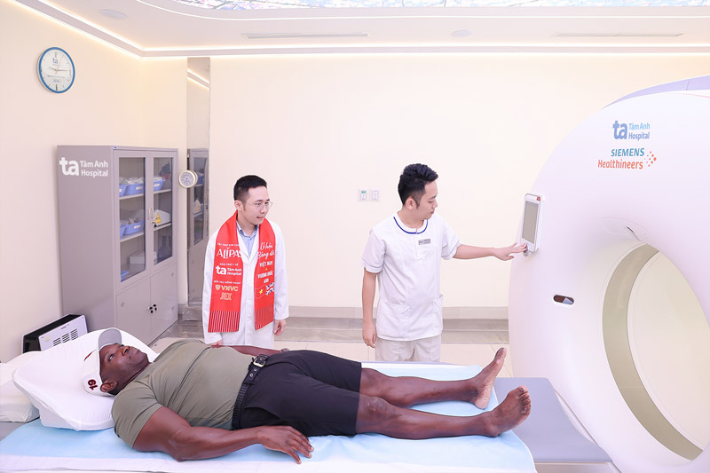 Danh thu Dwight Yorke trai nghiem chup sieu may CT Somatom Force VB30 ung dung AI dau tien tai Viet Nam de tam soat cac chan thuong tiem an. Anh: BVDK Tam Anh