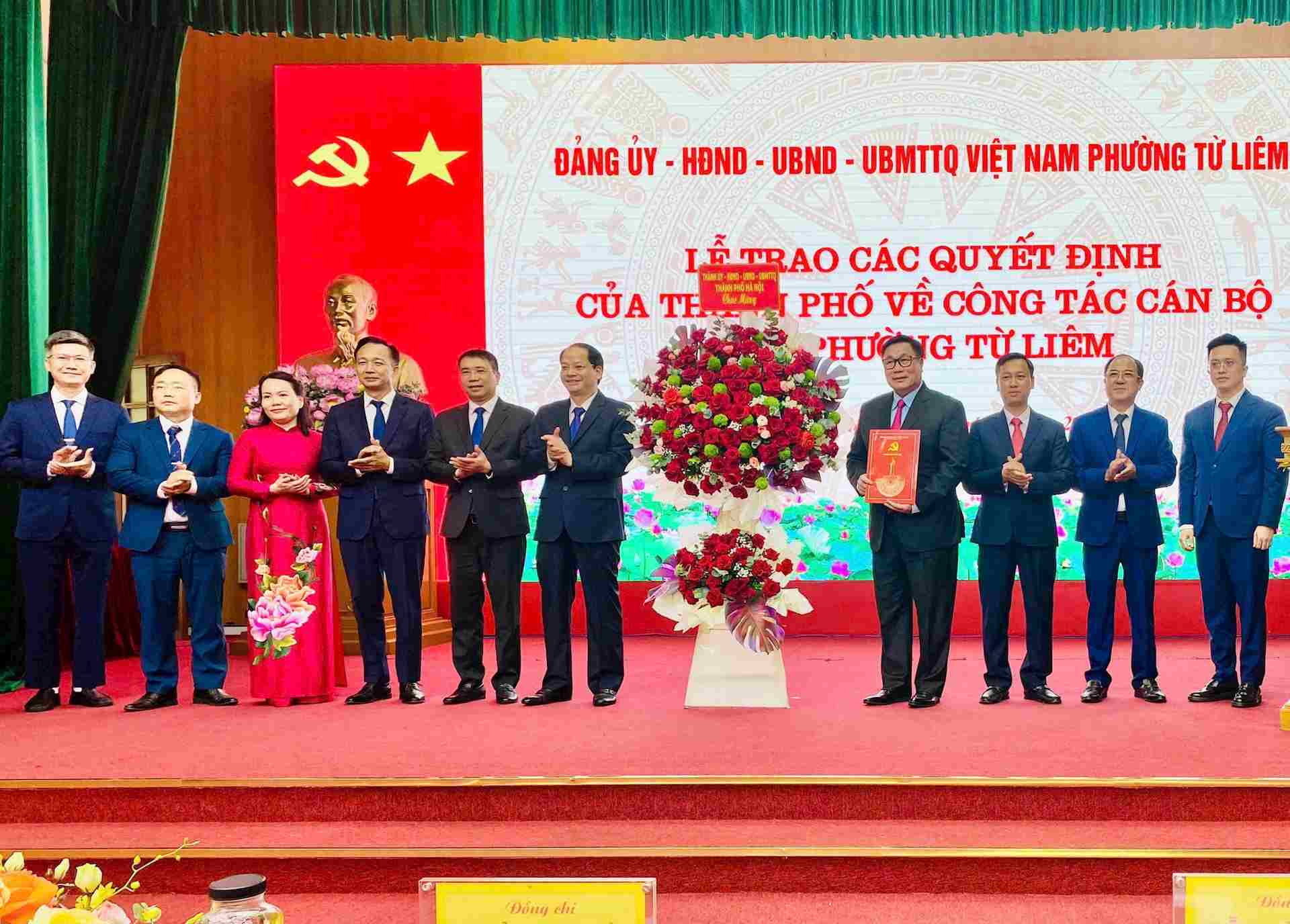 Truong ban Tuyen giao va Dan van Thanh uy Ha Noi Nguyen Doan Toan trao quyet dinh, tang hoa chuc mung cac dong chi lanh dao phuong Tu Liem. Anh: Huong Ly