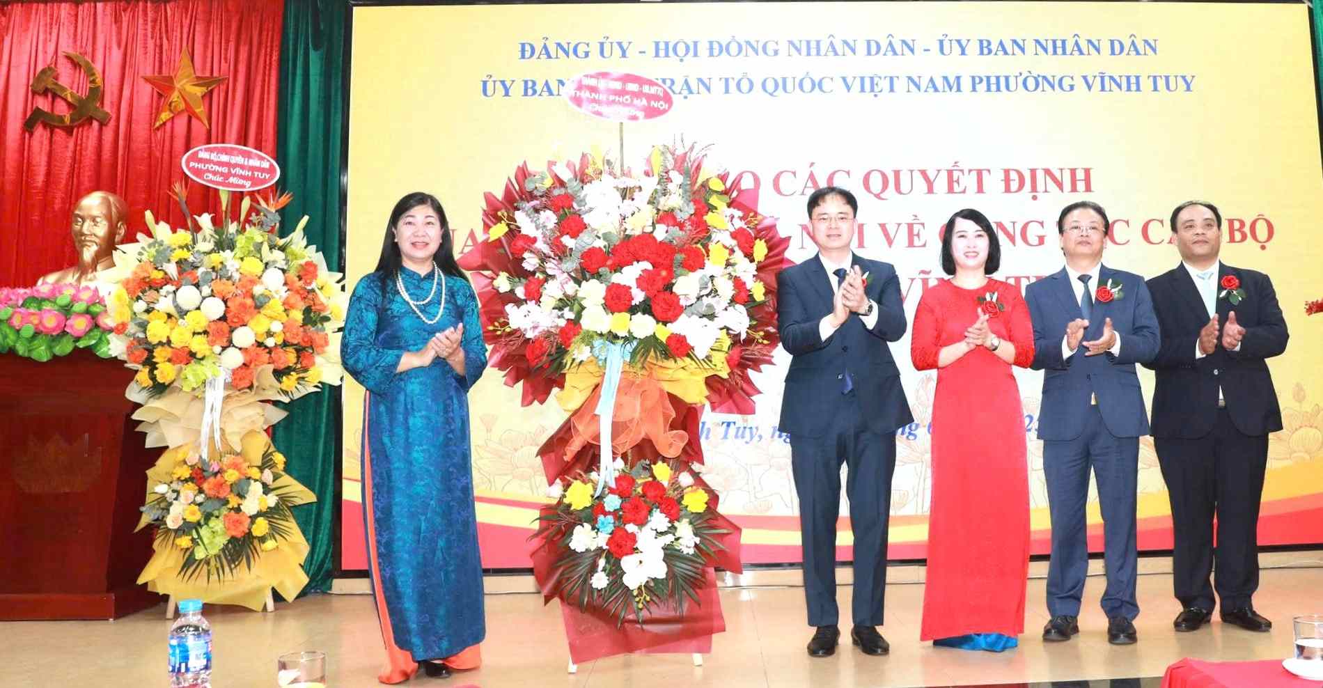 Nguyen Lan Huong 시 베트남 조국전선 위원회 위원장이 Vinh Tuy 구 지도자에게 꽃을 전달하며 축하하고 있습니다. 사진: Dinh Hiep