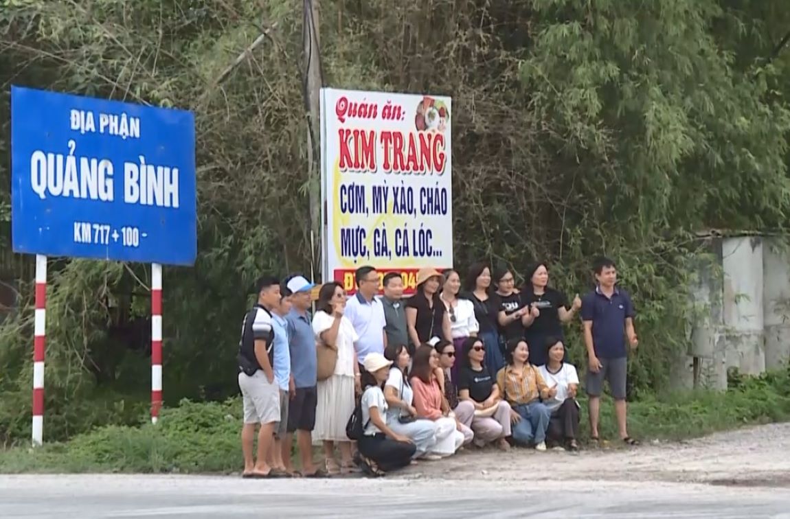 Nguoi dan chup anh luu niem voi bien chi dan dia gioi tinh Quang Binh. Anh: T.Hoang