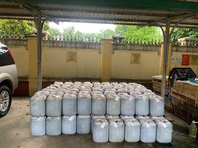 Une grande quantite de sauce de poisson d'origine inconnue est conservee dans des canettes en plastique detectee et detruite par la gestion du marche. Photo : QLTT HN