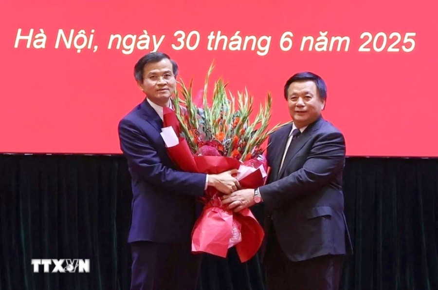 응우옌쑤언탕 중앙 이론위원회 위원장이 도안민후안 씨에게 결정서를 수여하고 꽃다발을 전달하고 있습니다. 사진: 반디엡/TTXVN