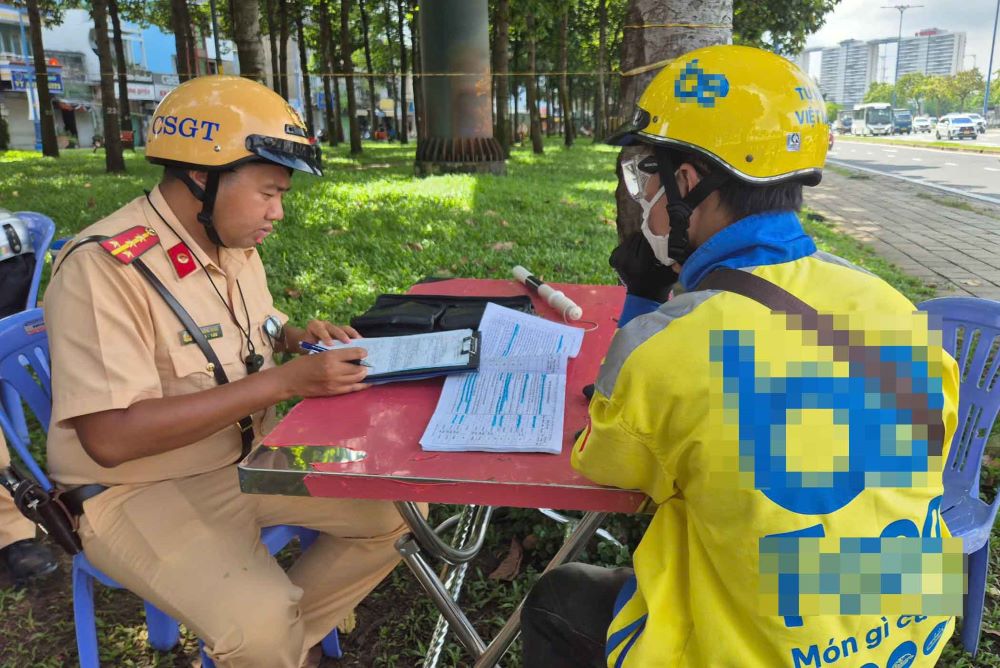 Anh L.A.T, lam nghe shipper cong nghe dieu khien xe may vuot qua toc do do quy dinh 65/50km/h bi CSGT lap bien ban, xu phat. Anh: Nguyen Chan