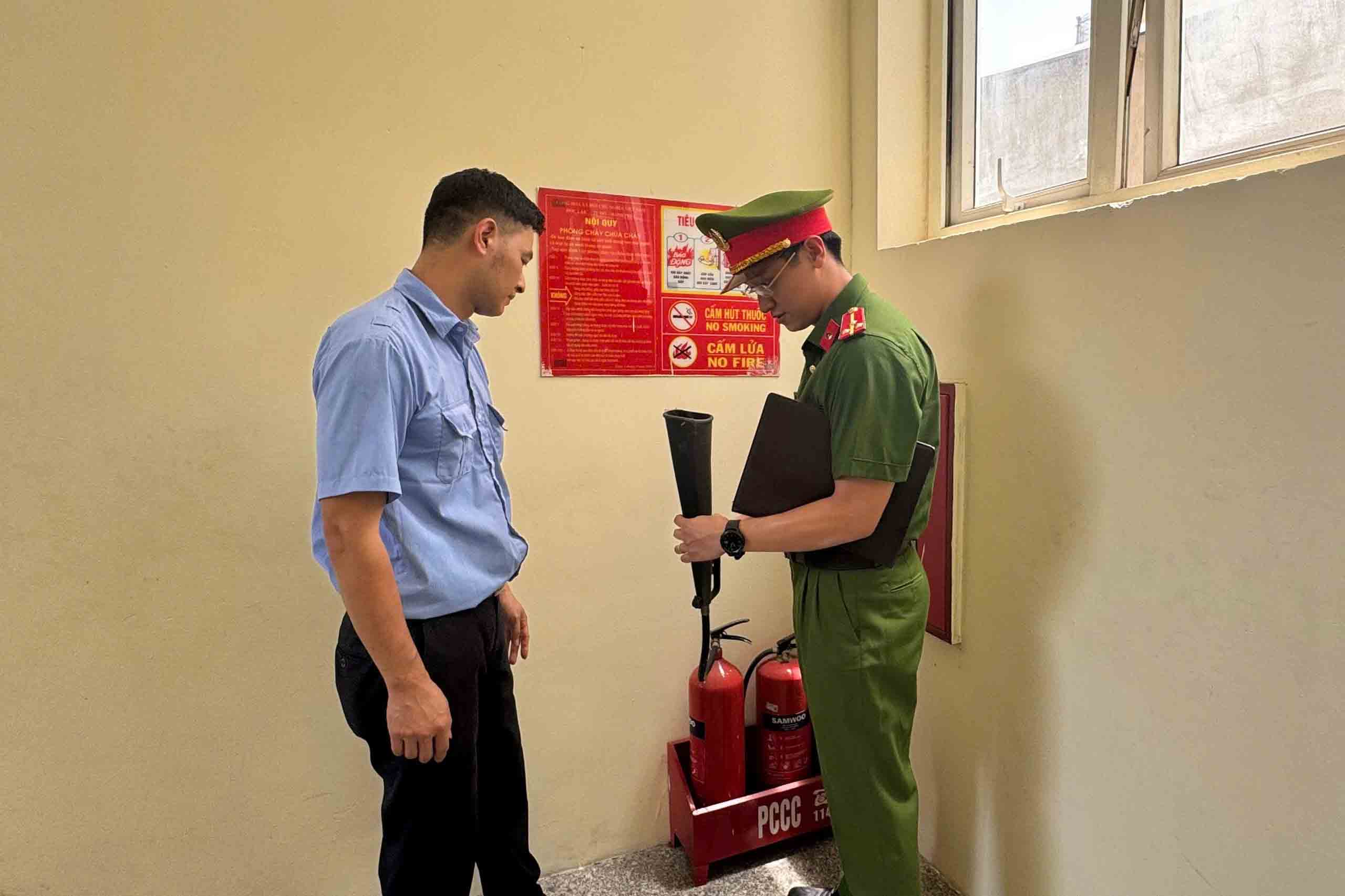 Hanoi Police instruct security guards to check fire fighting equipment at Nguyen Du Secondary School (Hoan Kiem District). Photo: Hanoi Police