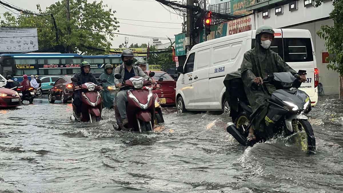 Tren duong Hiep Binh (TP Thu Duc), nguoi dan phai dat xe may bi bom trong dong nuoc den ngom, dong xe noi dai di chuyen cham qua khu vuc ngap nuoc. Anh: Nhom PV