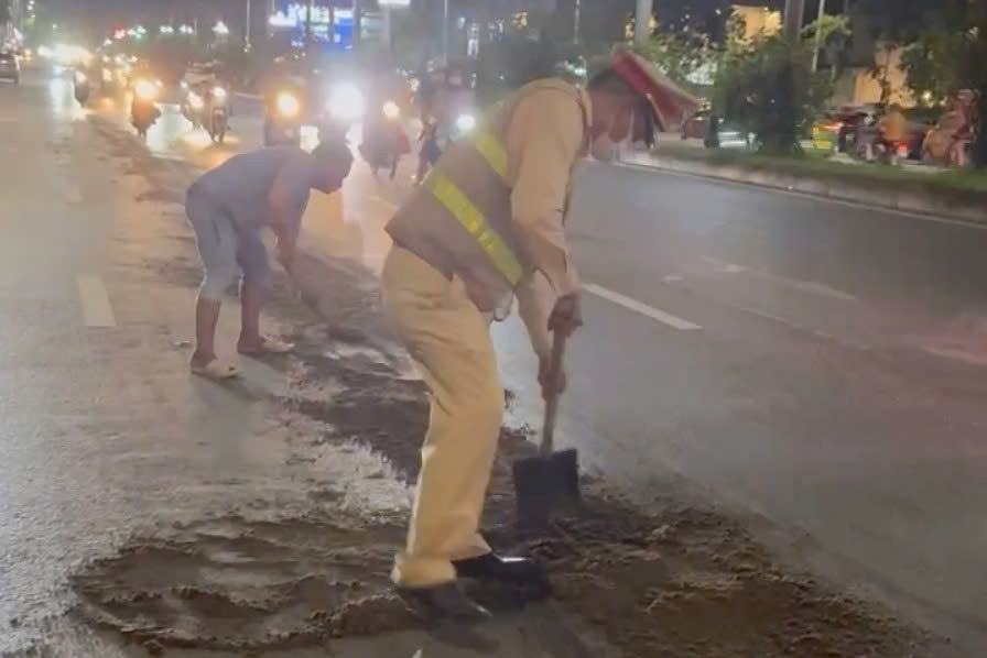 Traffic police handle oil splat on Tran Huu Duc Street. Photo: Hanoi Police