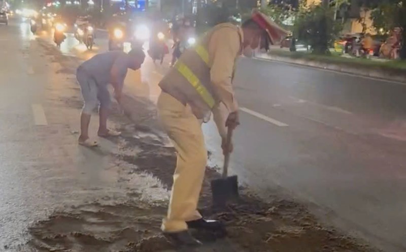 Traffic police handle oil splat on Tran Huu Duc Street. Photo: Hanoi Police